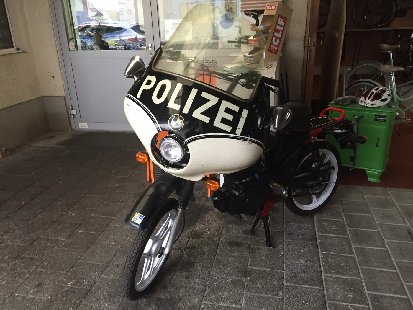 Umgebautes BMW-Mofa im Polizei-Look vor dem Geschäft