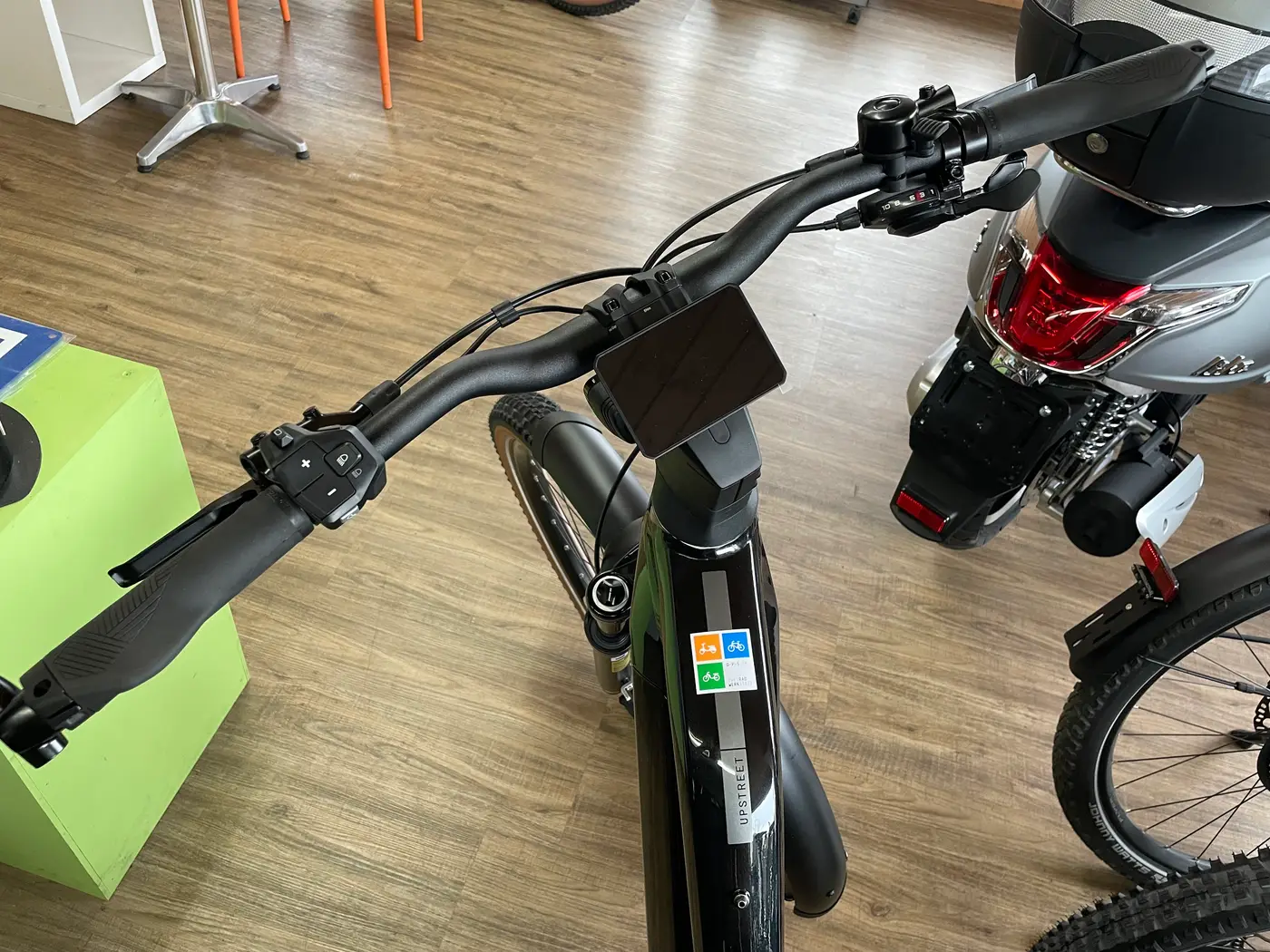 Gelbes FLYER E-Bike neben einem Roller im Geschäft